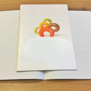 Ein liniertes Heft, das nicht nach Schule aussieht. Süße Knetfiguren auf dem Cover.