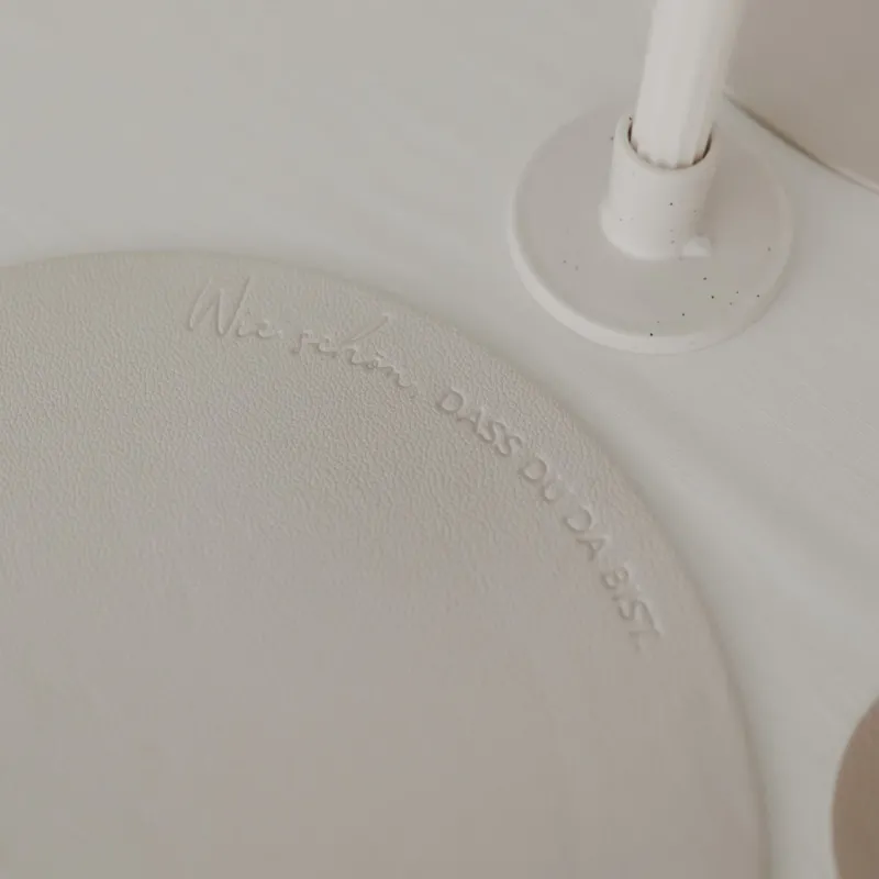 Detailaufnahme des Platzsets in Creme mit Schriftzug „Wie schön, dass du da bist“.